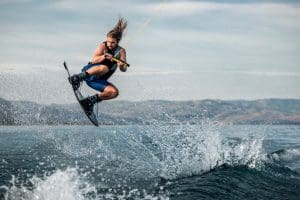 A man skillfully wakeboarding over ocean waves, capturing the thrill of summer water sports.